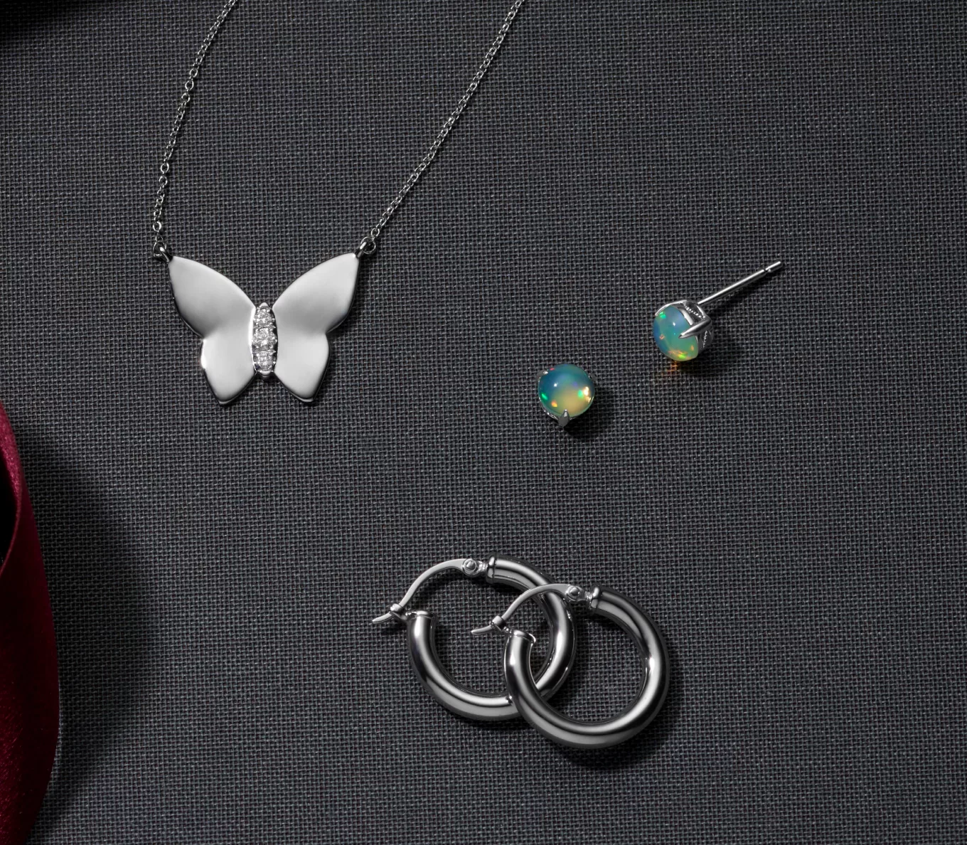 jewelry gifts under $250: butterfly necklace, opal earrings, hoop earrings. Diamond Butterfly Pendant in Sterling Silver
Natural diamond accents decorate the middle of this sterling silver butterfly pendant for a touch of beautiful sparkle. A cable chain with a spring clasp keeps this stylish necklace secure. Classic Sterling Silver Hoop Earrings
Add instant personality to any outfit with these sterling silver hoop earrings. They feature a secure yet easy lever back and rhodium plating to prevent tarnishing. Imogen Opal Studs
These earrings put the spotlight on the iridescent beauty of natural opals. Crafted in quality sterling silver, they feature milgrain detail around the profile. Clean natural opal gently in warm water with mild detergent and a soft toothbrush or cloth. Avoid bleach, chemicals and cleaners, and rapid temperature changes.