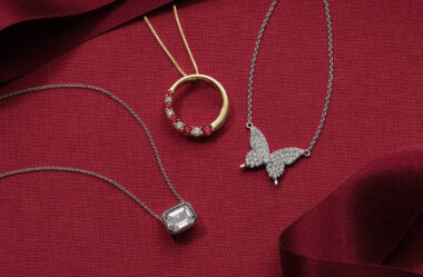 jewelry gifts: butterfly necklace, diamond and ruby necklace, diamond pendant necklace all on a red backdrop