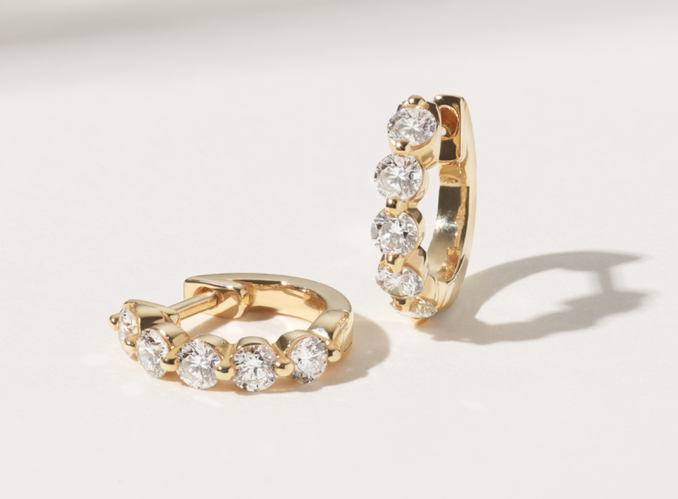 Terra 0.40 tcw Diamond Huggie Hoops A minimal yet secure single-prong setting showcases the gorgeous round shape and superior sparkle and fire of the natural diamonds along these huggie hoop earrings. Crafted in warm 14-karat yellow gold, a hinge back keeps these beauties secure.