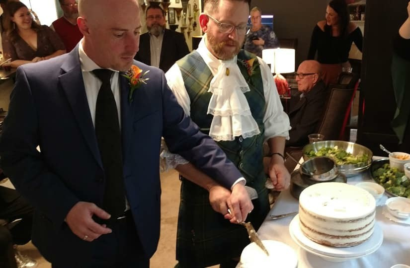 David and Lea cutting cake at their wedding.