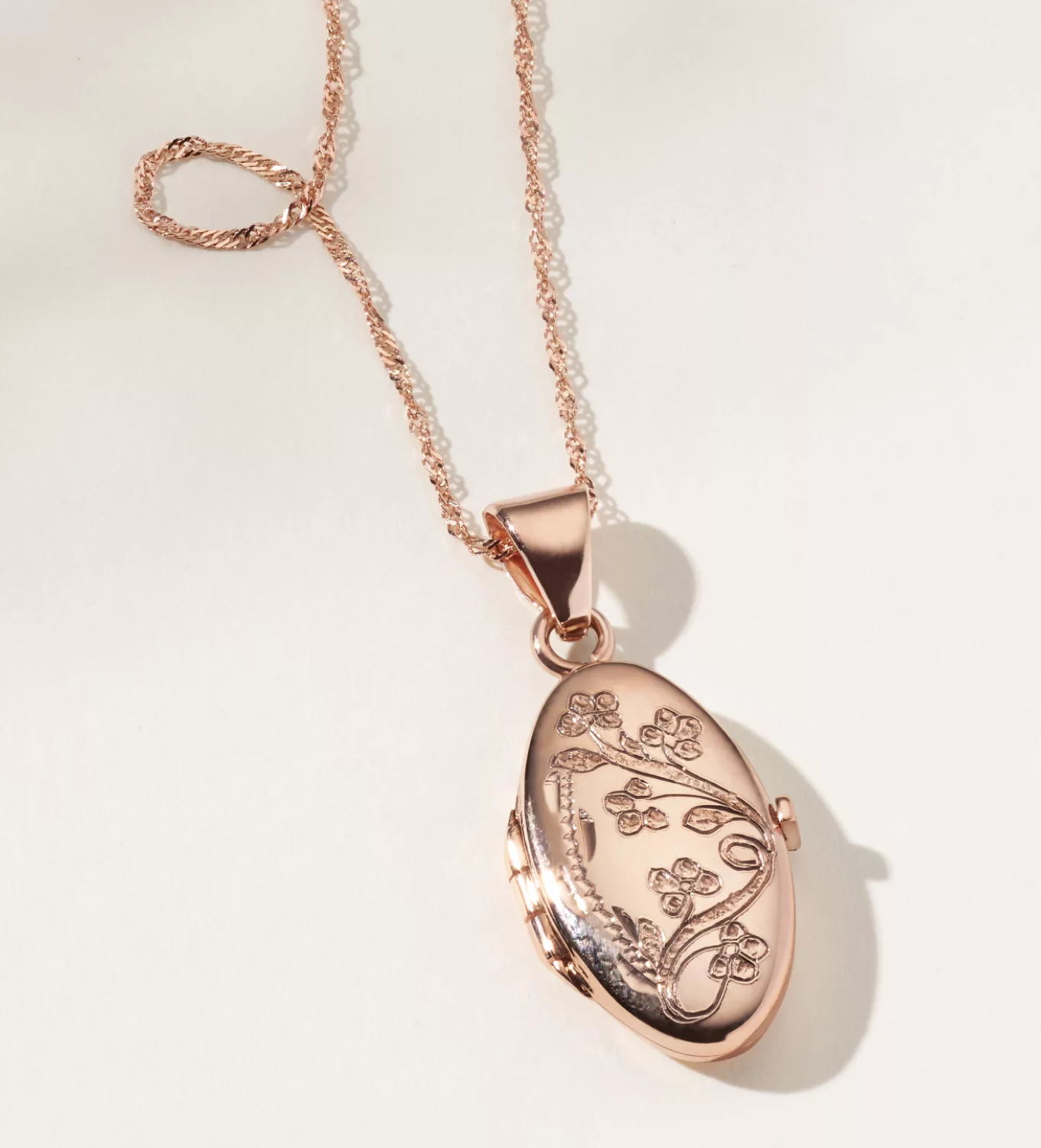 rose gold locket Floral 14K Rose Gold Oval Locket (20 in) This beautiful locket features a floral engraving on the front and a photo slot inside to keep loved ones close. Crafted in vivid 14-karat rose gold, it hangs from a matching adjustable Singapore chain. Add an engraving to the back for further personalization. 