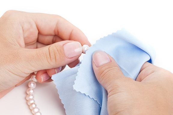 Woman cleaning pearls with a cloth.