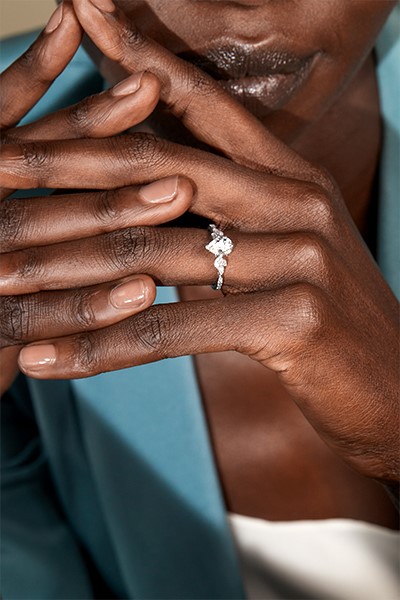 Close-up of a woman's hand wearing a pear shaped diamond engagement ring.