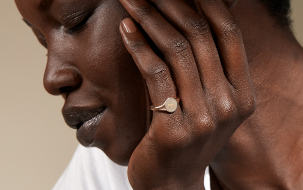 Woman wearing engraved gold signet ring.