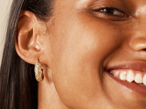 Woman wearing 14k yellow gold hoop earrings.