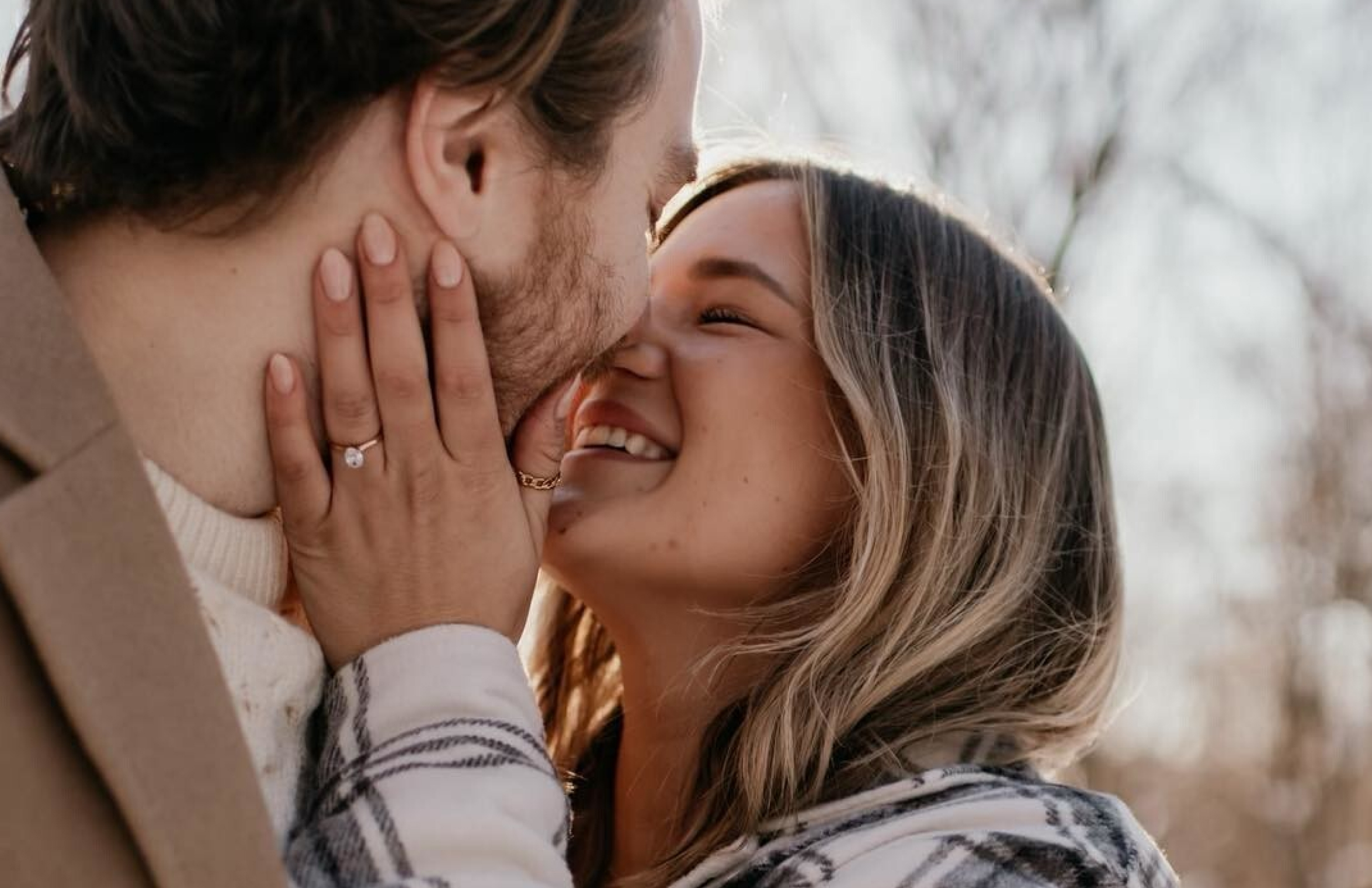 Couple smiling and kissing after a proposal