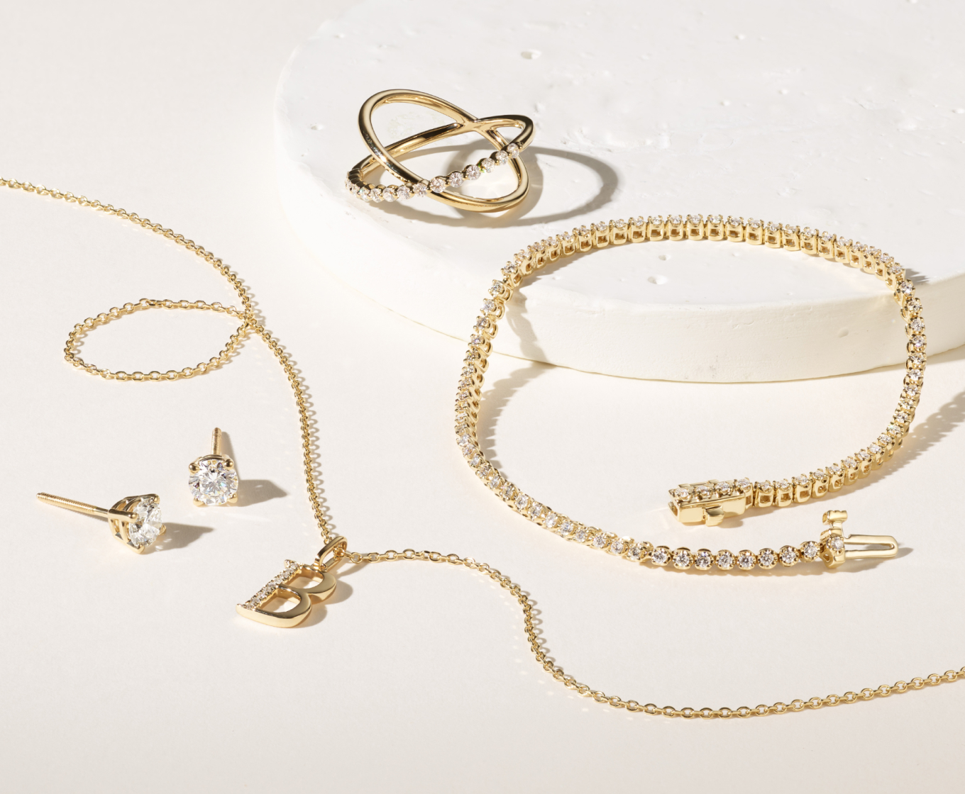 STUD EARRINGS Choose from our wide selection of stud earrings that come in all shapes and sizes. Diamond Letter B Pendant in 14k Yellow Gold (18 in) Crafted in quality 14 karat yellow gold, nine brilliant round natural diamonds, at approximately .04 carats, create an eye-catching letter B pendant. This natural diamond letter charm measures 5/8 inch long (including the O-ring ) and hang from a matching 18-inch cable chain. Xyla Crossover Diamond Ring Showstopping enough to dress up an outfit yet simple enough to wear everyday, this ring will make a statement. Crafted in warm 14-karat yellow gold, this ring features round natural diamonds in a trending criss-cross design. 1 ct. Diamond Tennis Bracelet (7.25 in) Embody simple elegance with this darling tennis bracelet. The natural diamonds beautifully represent love, strength, and health. The 14-karat yellow gold has added zinc, silver, and copper alloys to create a bright shade. The push lock clasp will hold this bracelet securely in place.