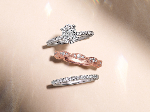Oval diamond engagement ring with two stackable wedding bands.
