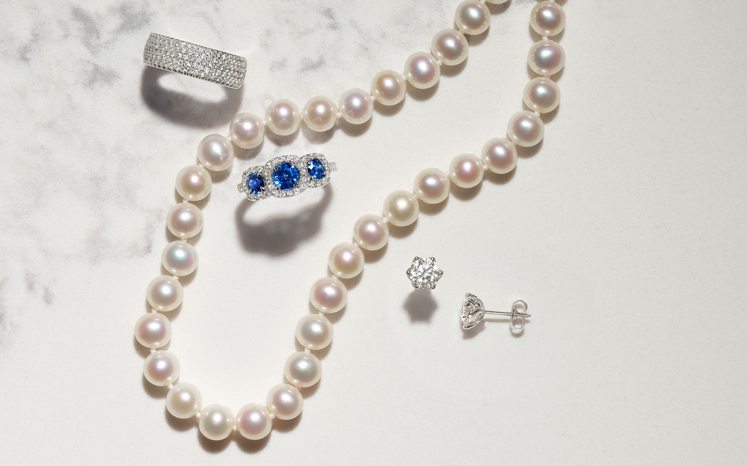Pearl necklace, stud earrings, and two rings.