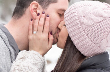 man and woman kissing after winter proposal.