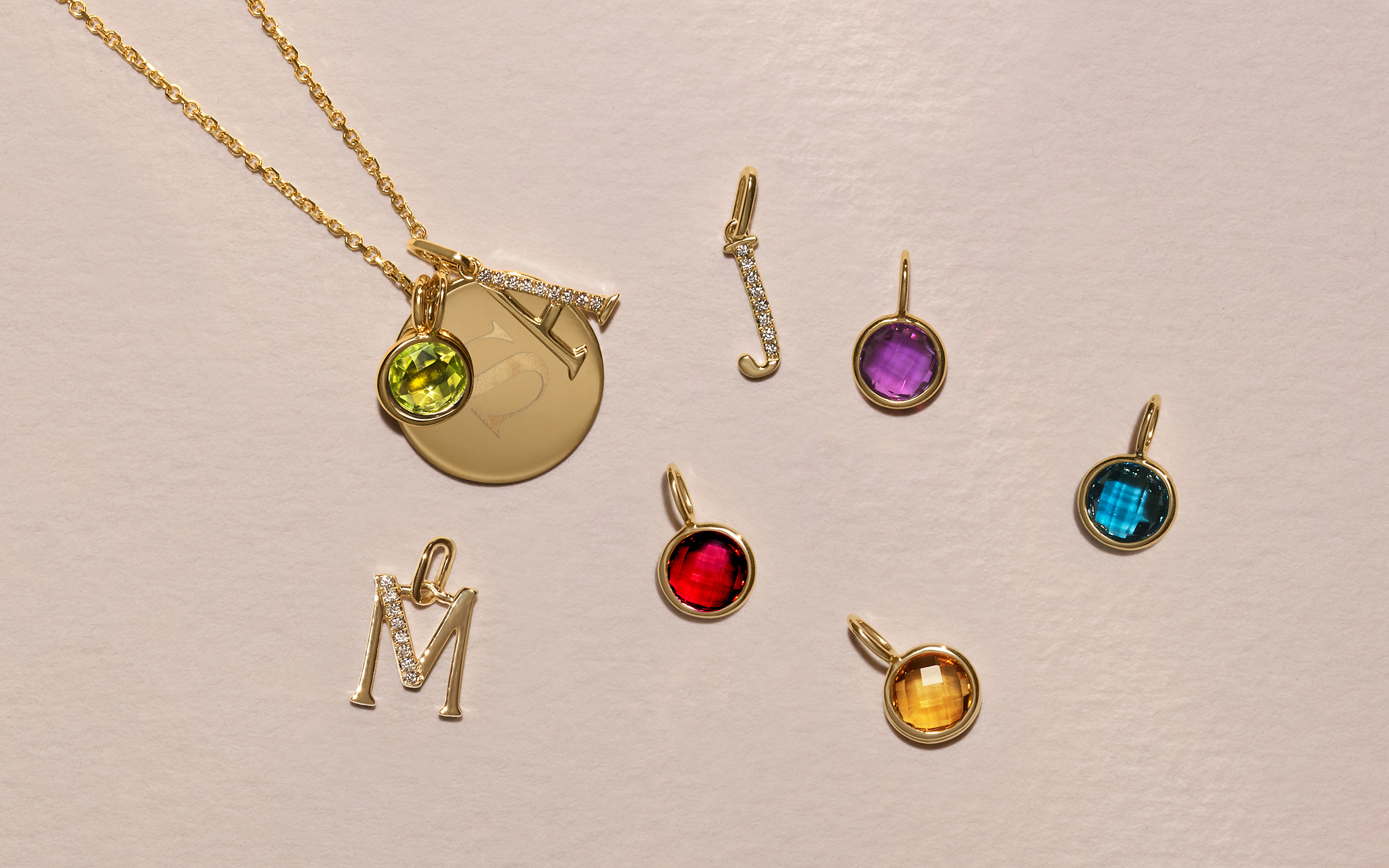 Engraved 14k gold pendant, 14k gold initial pendants, and gemstone charms.