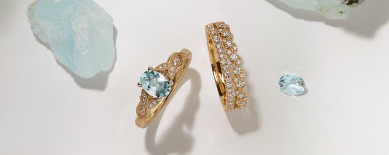 Matching wedding ring set featuring an aquamarine center stone in yellow gold. An engagement ring and wedding band set