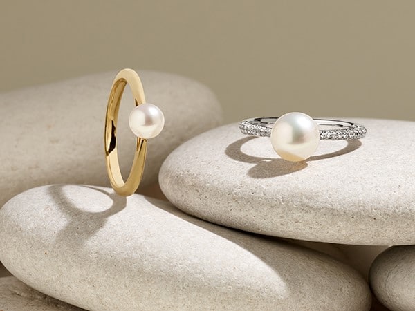 two Pearl rings, one in yellow gold and the other with a pave set white gold ring