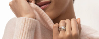 image of woman in sweater with stacked gold rings around her engagement ring