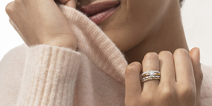 image of woman in sweater with stacked gold rings around her engagement ring