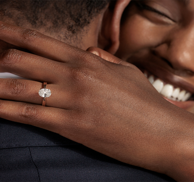 couple hugging and smiling after receiving one of a kind engagement ring