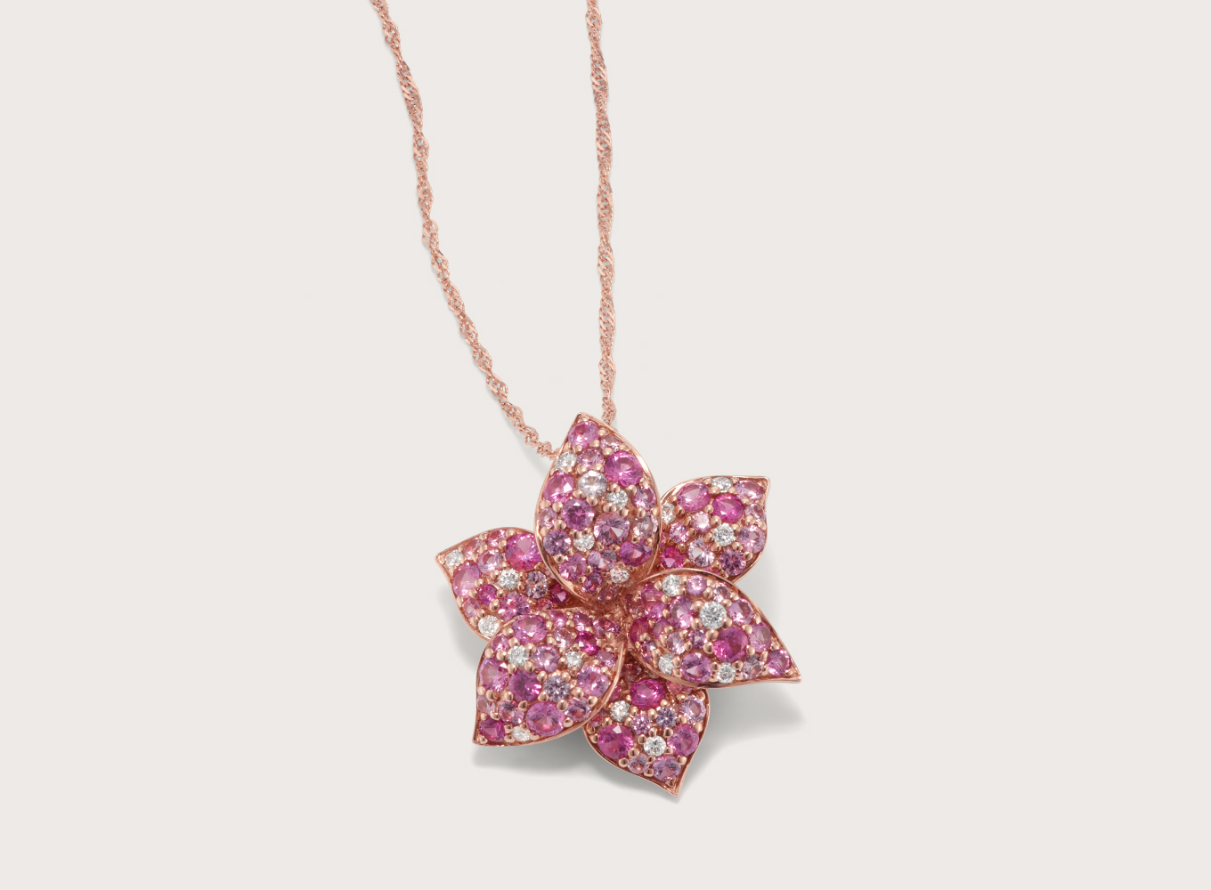 Mosaic Pink Sapphire & Diamond Flower Pendant Natural diamonds and varying shades of natural pink sapphire decorate the petals of this flower pendant with stunning color. Crafted in vivid 14-karat rose gold, a matching Singapore chain with a lobster clasp keeps this look secure.