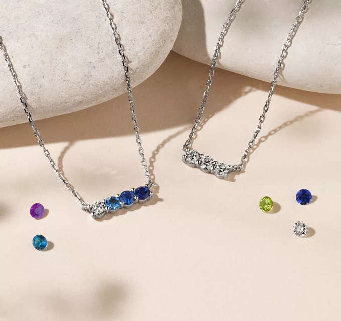two multi stone necklaces that can be customized with many different gemstones, pictured with diamond and sapphire