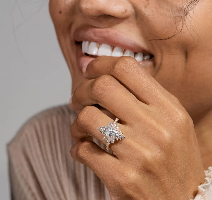 woman wearing a star burst halo diamond ring