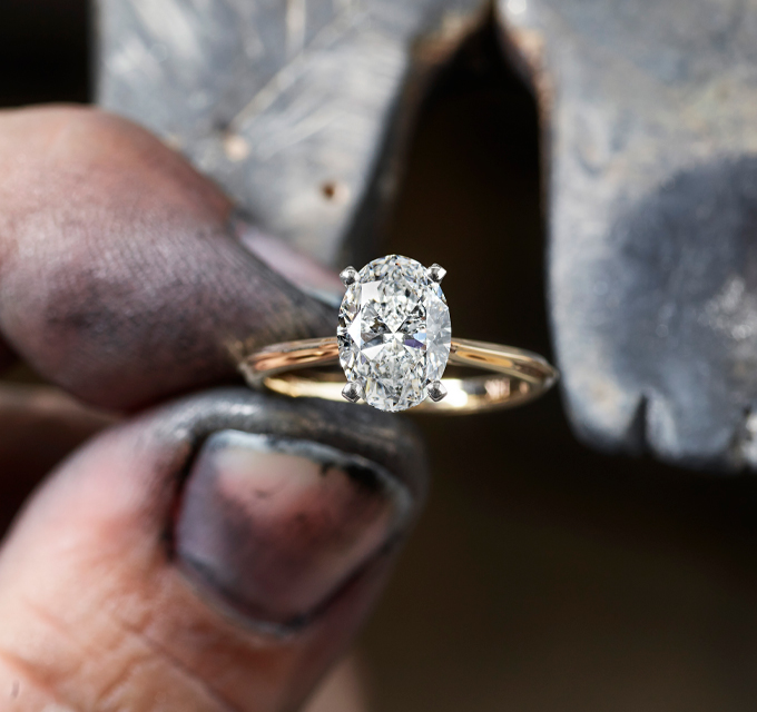 oval cut diamond ring being worked on by a jeweler