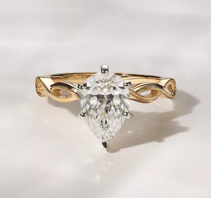 pear shaped diamond ring with yellow gold infinity band