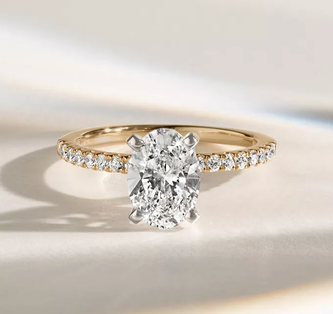 Timeless Oval Diamond Engagement Ring with Pave Setting. 14k yellow gold, 16 round accenting natural diamonds at approx. 0.20 tcw, 1.5mm band width, Engravable and resizable