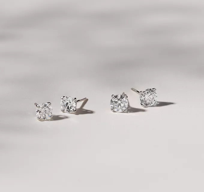 two pair of diamond stud earrings