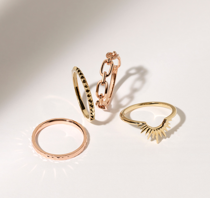 four gold rings, featuring stackable and link designs