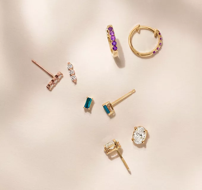 various gold earrings, featuring colorful gemstones