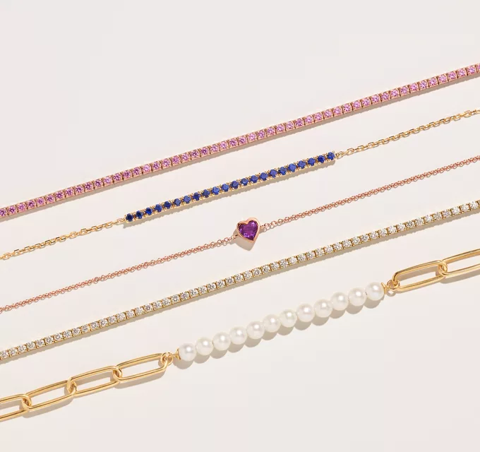 variety of bracelets in gold.  featuring colorful gemstones and diamonds