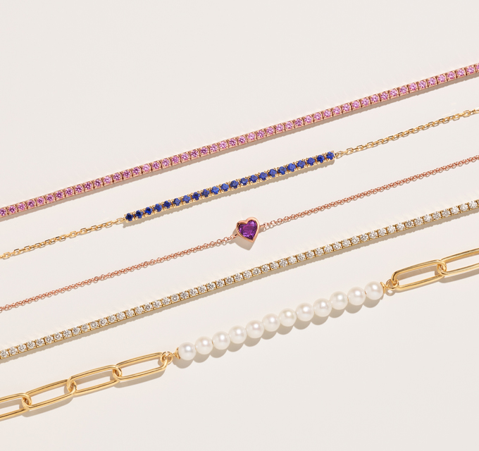 variety of bracelets in gold.  featuring colorful gemstones and diamonds