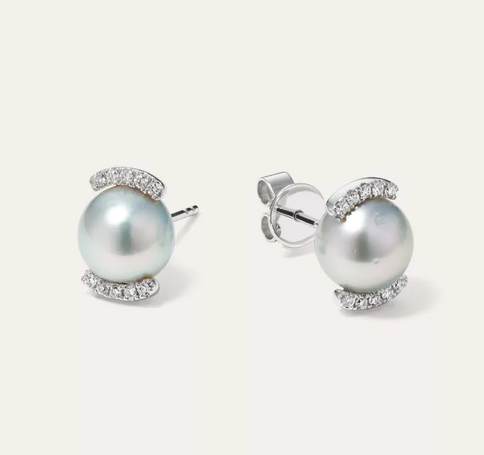 Silver Akoya Pearl Halo Earrings. A baroque cultured Akoya pearl beams with a soft silver sheen among a partial halo of natural diamonds in these stunning 14-karat white gold earrings. 2 baroque cultured silver Akoya pearls at 7-8mm, 20 round natural diamond accents at approx. 0.10 tcw, Halo design