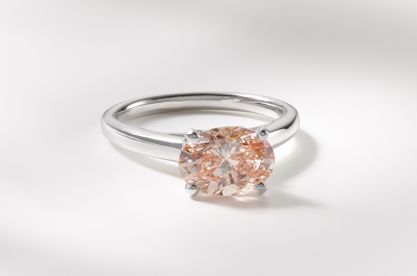 An oval shape fancy pink lab-grown diamond set in a white gold ring