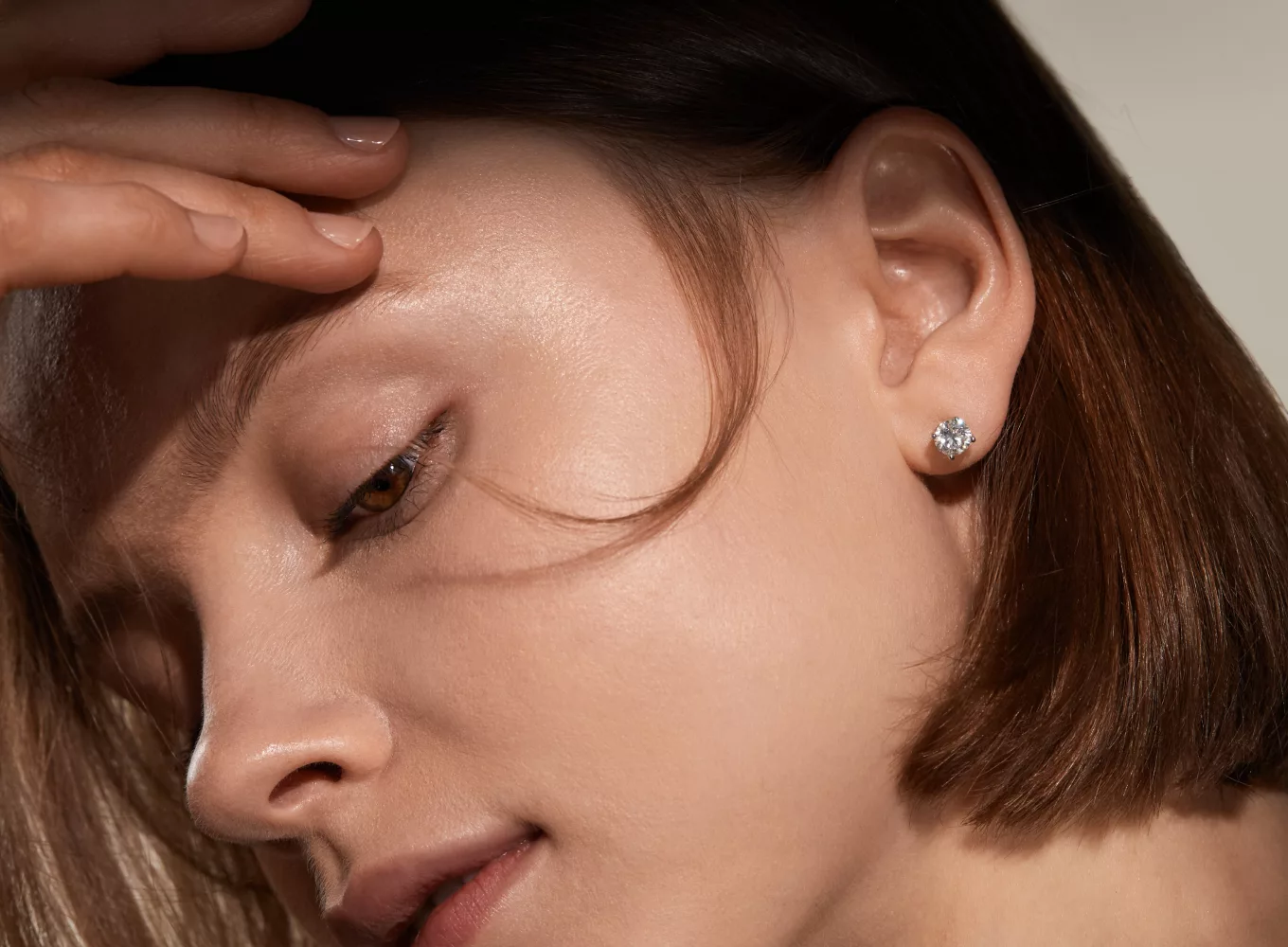 woman showing off a diamond stud earring
