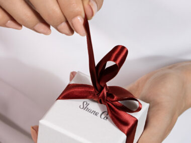 Shane Co. jewelry box with red ribbon around it
