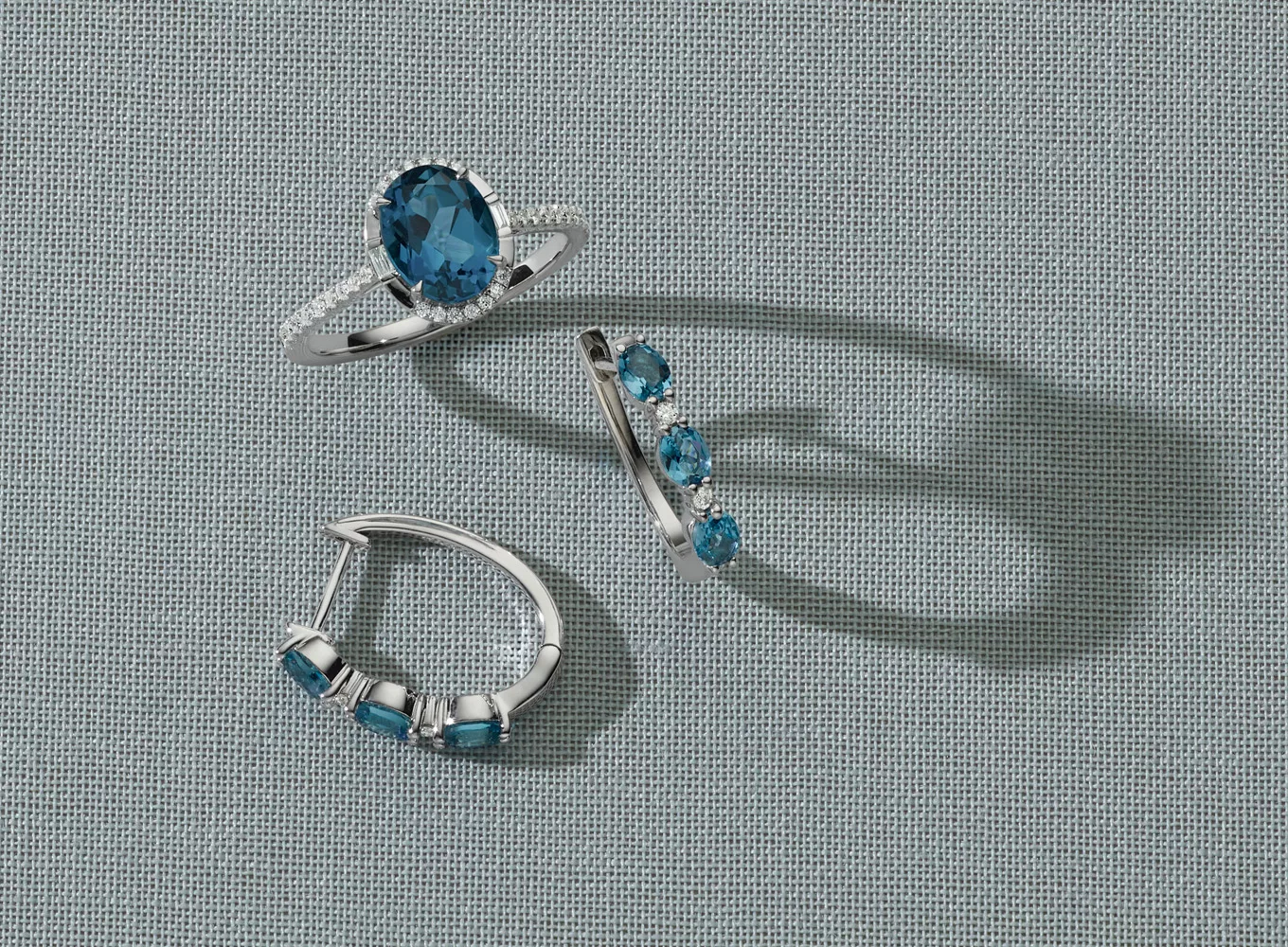 white gold ring and sterling silver hoop earrings: Monterey London Blue Topaz & Diamond Halo Ring with a gorgeous oval natural London Blue topaz gemstone at its center in a14-karat white gold ring. Blue Topaz & Diamond Hoops in Sterling Silver adds a pop of color to any look with these natural London blue topaz hoop earrings. Crafted in quality sterling silver, they feature natural diamond accents between each gemstone for a touch of sparkle.