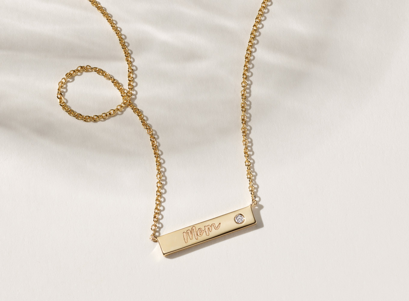 Diamond Accent Engravable Bar Necklace (18 in). Featuring a natural diamond accent for a touch of sparkle, this this 14-karat yellow gold bar necklace is the perfect canvas for a custom engraving. A matching cable chain with a lobster clasp offers worry-free daily wear.
