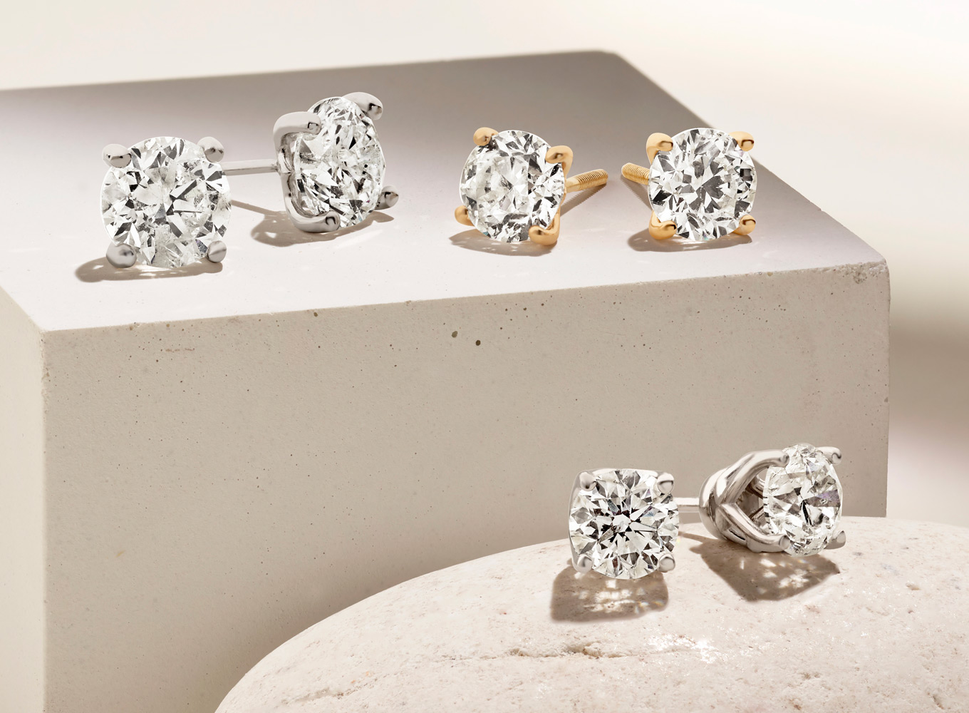 three pair of diamond stud earrings with progressively larger diamonds highlighting the Shane Co. upgrade policy