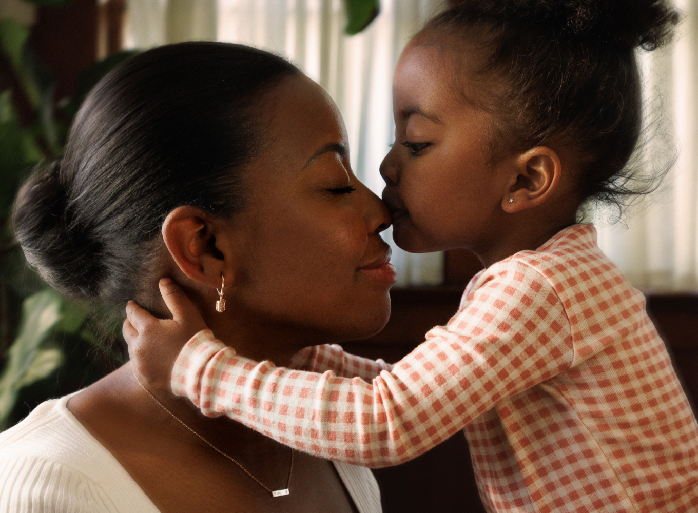 image of mom and daughter. Daughter is kissing mom's nose. Incorporate the 2024 Pantone Color of the Year into your jewelry wardrobe with peachy morganite.