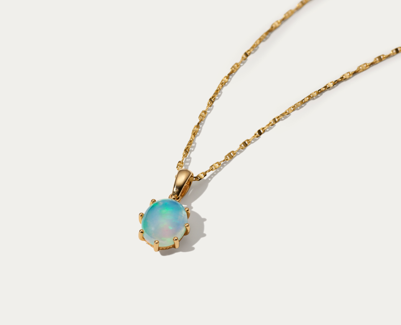 Celia Opal Pendant (18 in) Add luminous color to your look with this natural opal pendant. Crafted in warm 14-karat yellow gold, it features a stylish oval shape and subtle milgrain detail around the base of the gemstone. A stylish and sturdy anchor chain with a lobster clasp keeps this necklace secure. Clean natural opal gently in warm water with mild detergent and a soft toothbrush or cloth. Avoid bleach, chemicals and cleaners, and rapid temperature changes.