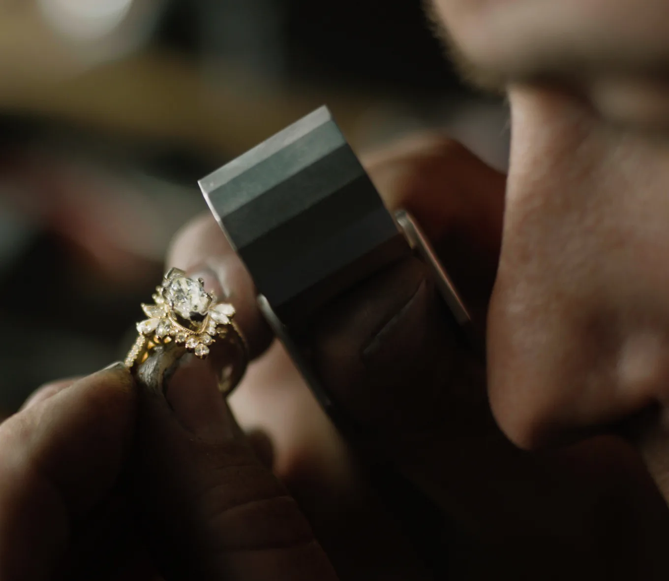 Jeweler examining a diamond engagement ring through a loupe