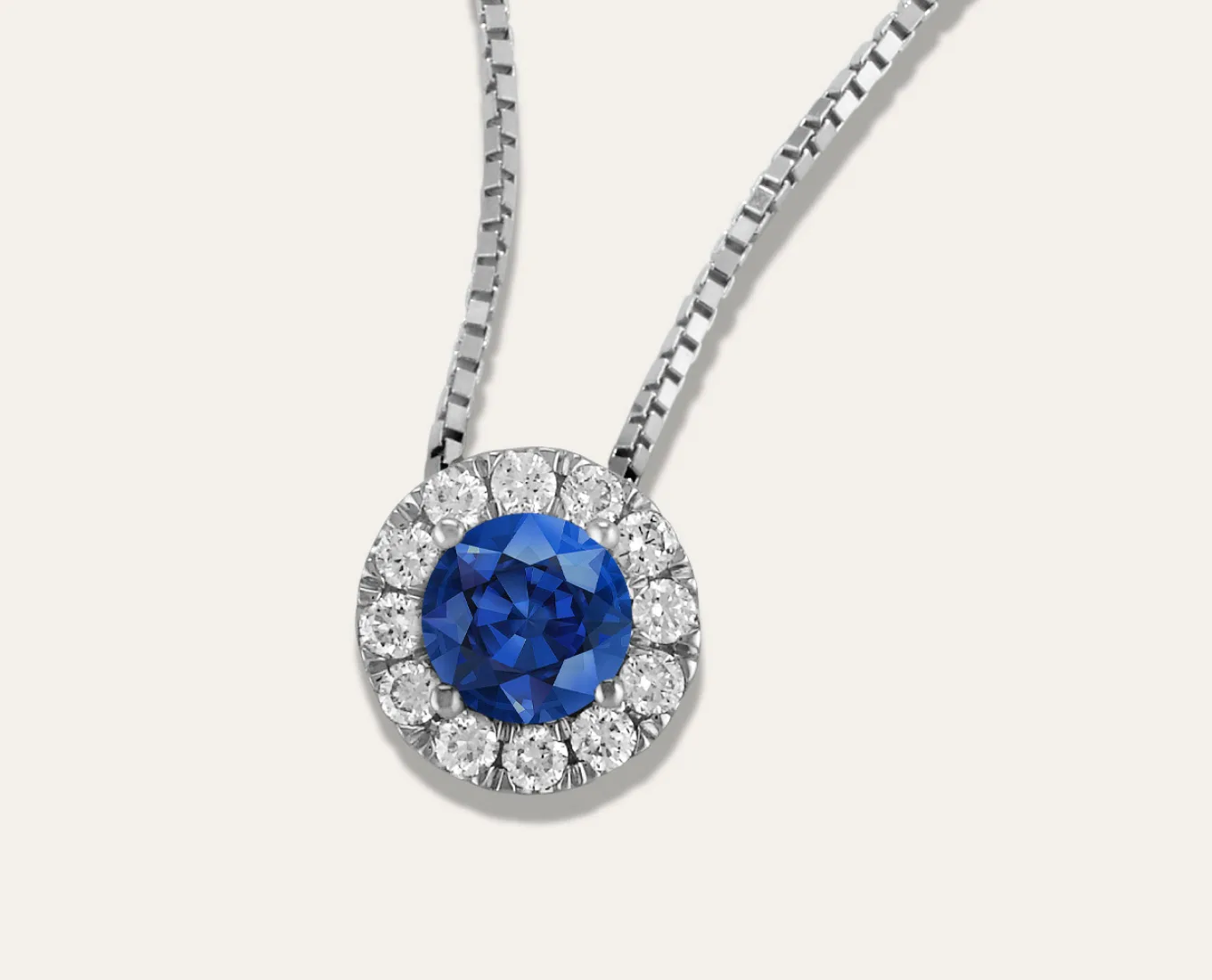 Leda Pick-Your-Gem Halo Pendant (5mm Round) Featuring a Sapphire Center Stone. Natural diamonds will add sparkle to a birthstone or a favorite gemstone in this beautiful halo pendant. Crafted in bright 14-karat white gold, it comes on a matching box chain. For more information on selecting your gemstone, Live Chat online, call a customer service representative at 1-866-467-4263, or visit one of our store locations.