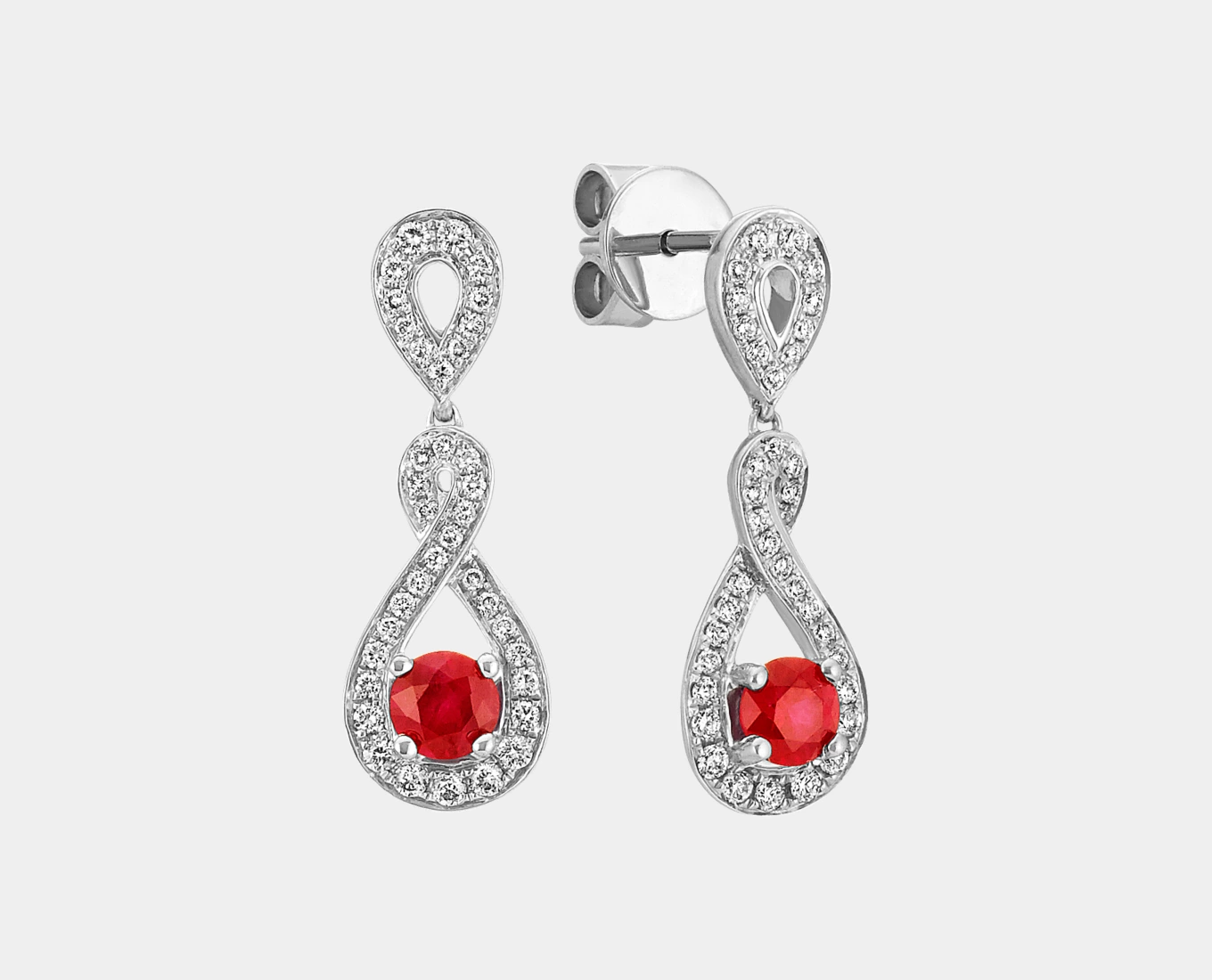 Ruby and Diamond Swirl Earrings
Seventy-four round natural diamonds (approx. .30 carat TW) highlight two round natural rubies (approx. .52 carat TW) in this swirl style. Crafted of quality 14 karat white gold, the elegant designs measure 7/8 of an inch long and are secured with friction posts and backs. The total gem weight is approximately .82 carat.