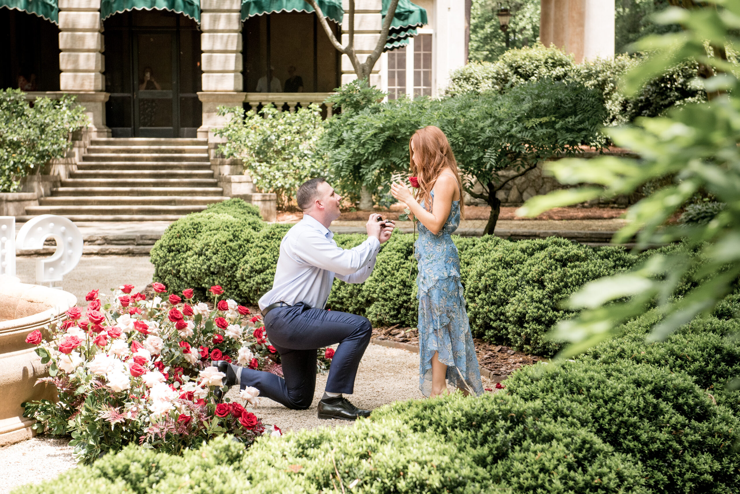 man proposing to woman at the Swan House in Atlanta