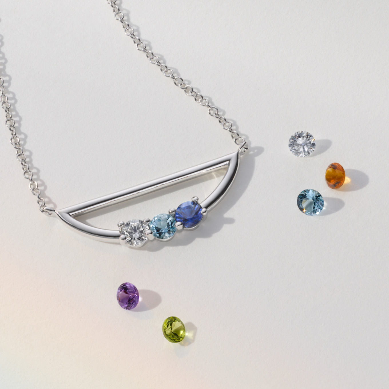 From birthstones to favorite colors, add the three round gemstones of your choice to this 14-karat white gold necklace for a meaningful gift or beautiful everyday accessory. It features a stylish curved design and comes on an adjustable rolo chain with a lobster clasp for worry-free wear.
