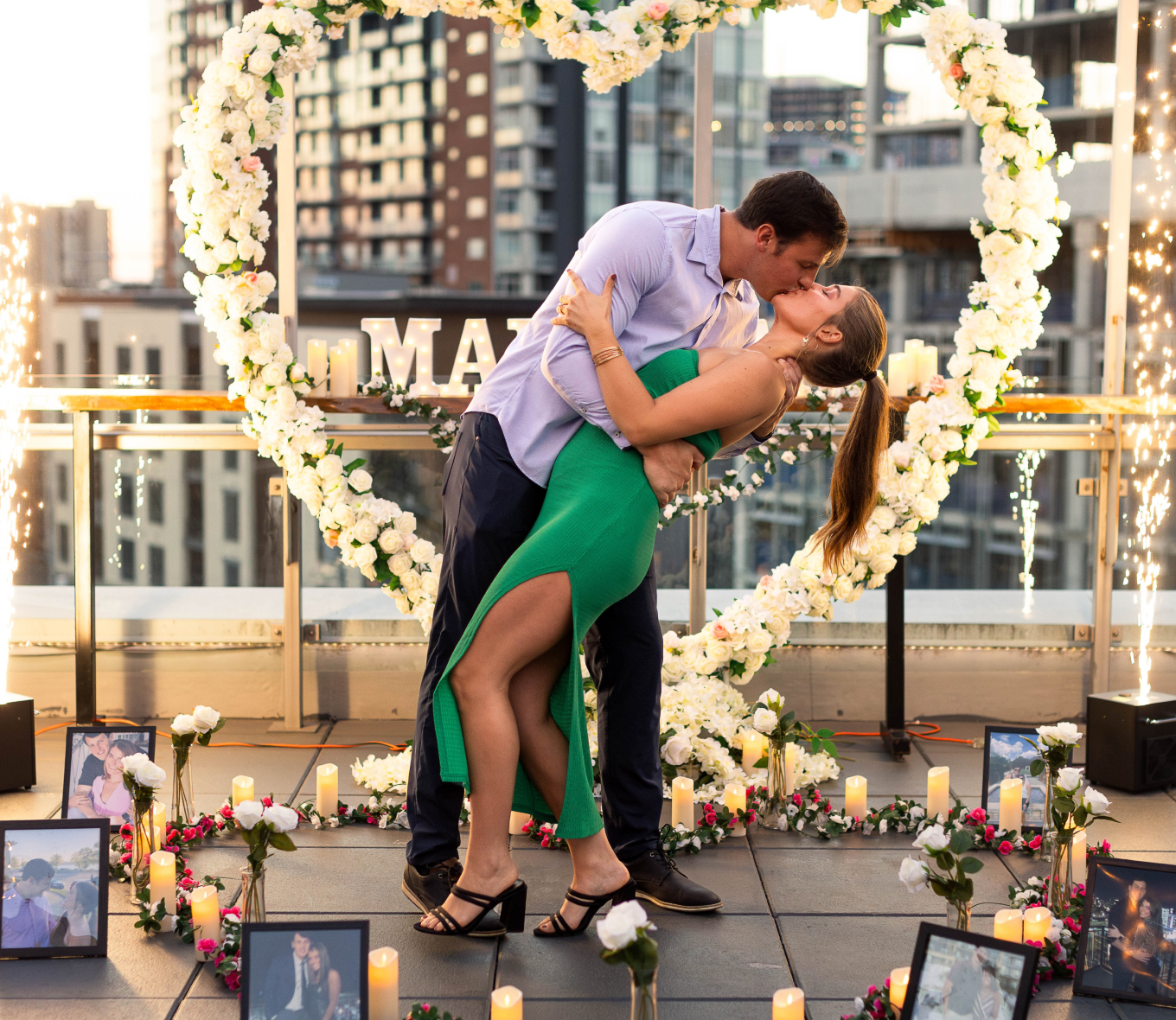 couple celebrating proposal in a heart backdrop
