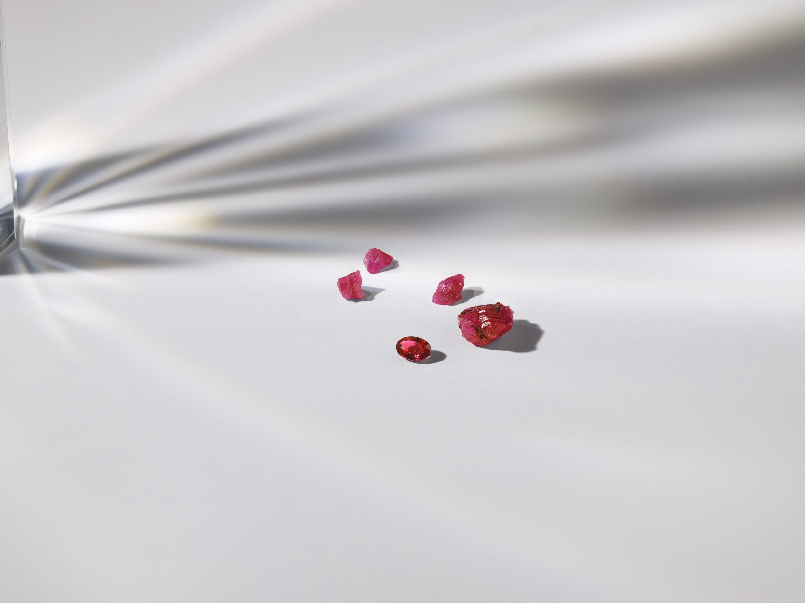 image of rough ruby gemstones and an oval cut ruby gemstone