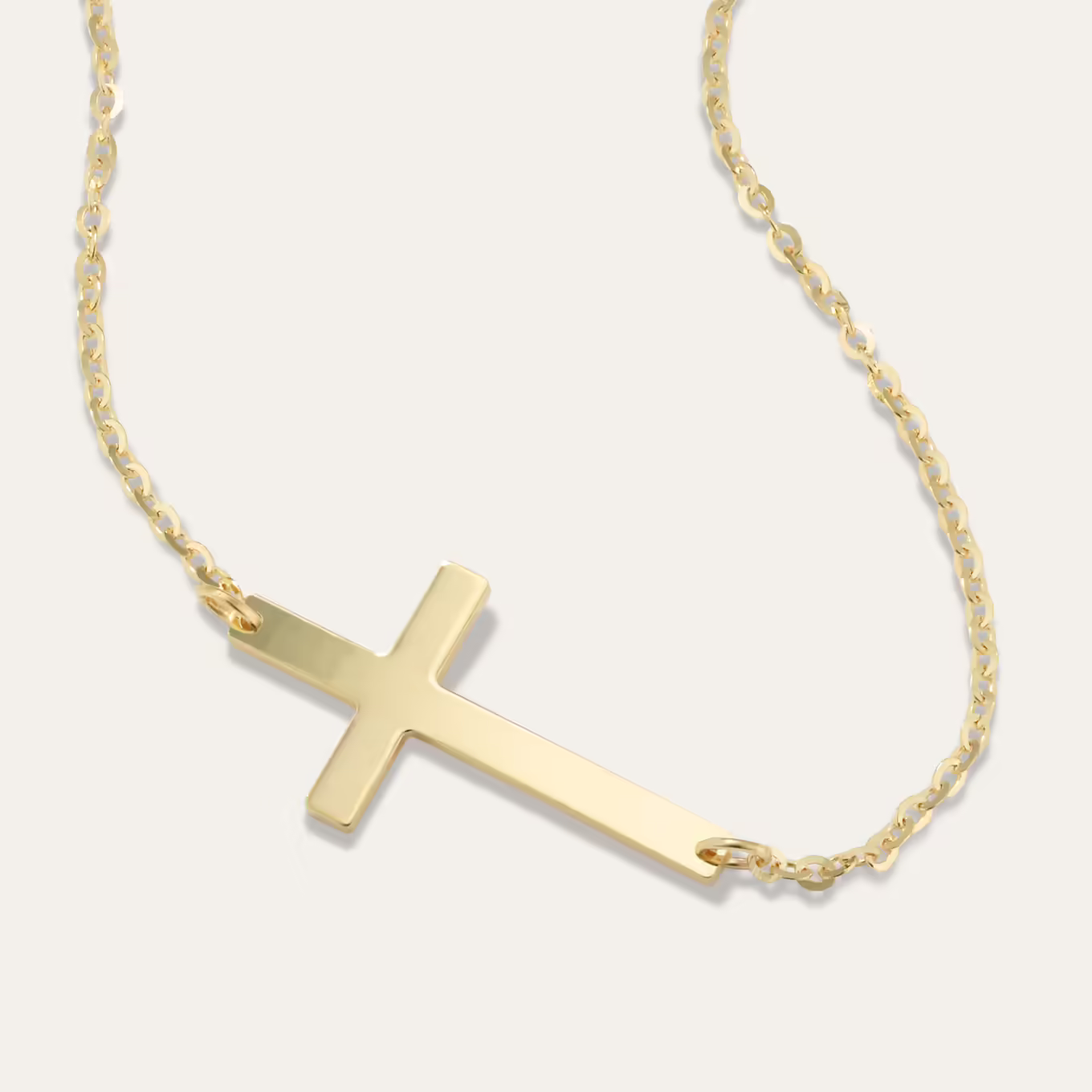 14K Yellow Gold Sideways Cross Necklace This 14-karat yellow gold cable chain features a stylish sideways cross at the front. It makes a beautiful daily accessory or a meaningful gift.